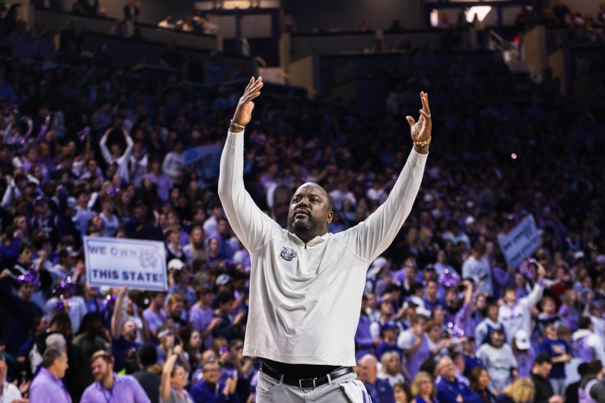 Assistant coach Jareem Dowling walks around the court during a timeout to encourage fans to get up and be loud as K-State battles No. 4 Kansas. The Wildcats took the Jayhawks into overtime, resulting in a win of 75-70 on Feb. 5 in Bramlage Coliseum. 