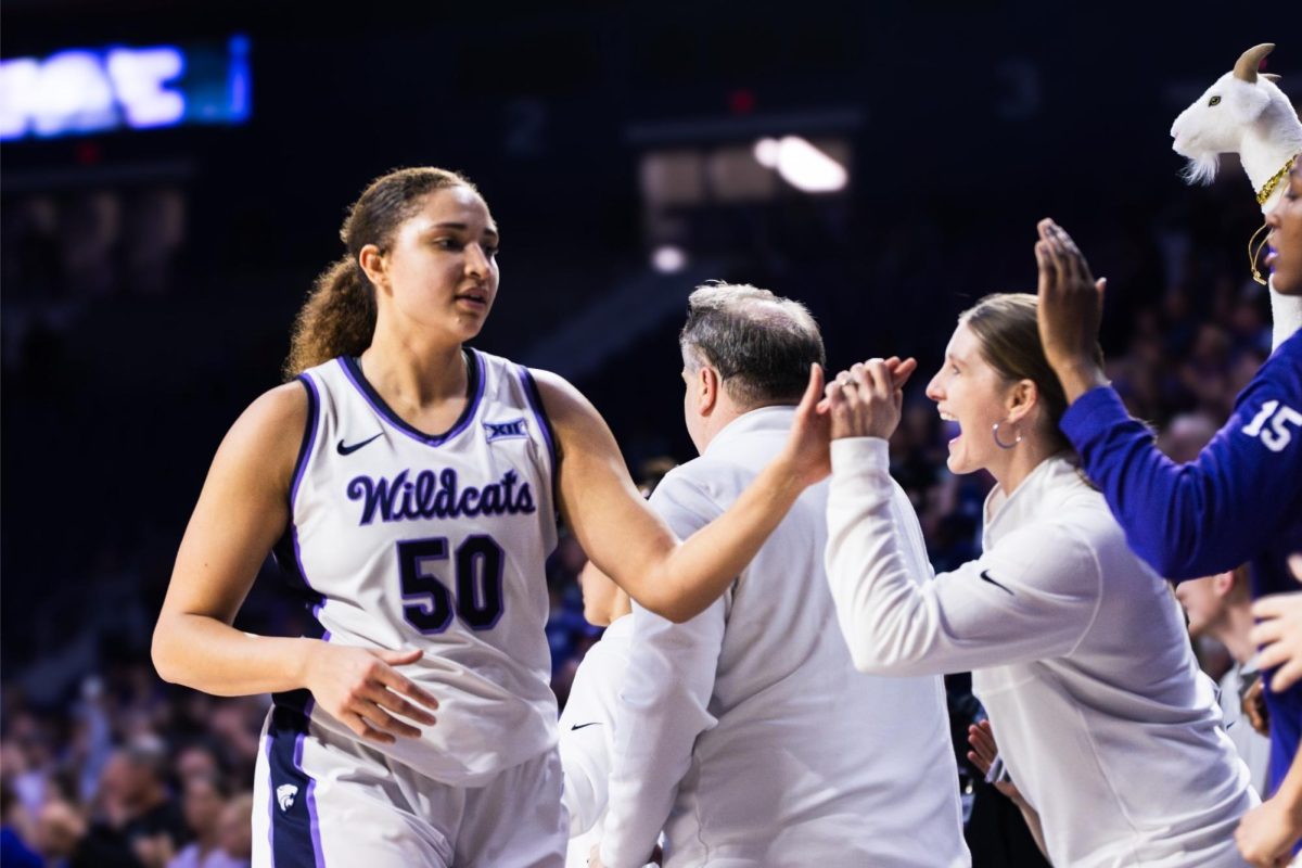 Center Ayoka Lee high fives her coach on the way to the bench. In 26 minutes, Lee scored 34 points and picked up 12 rebounds in K-State's 73-64 overtime victory over West Virginia.