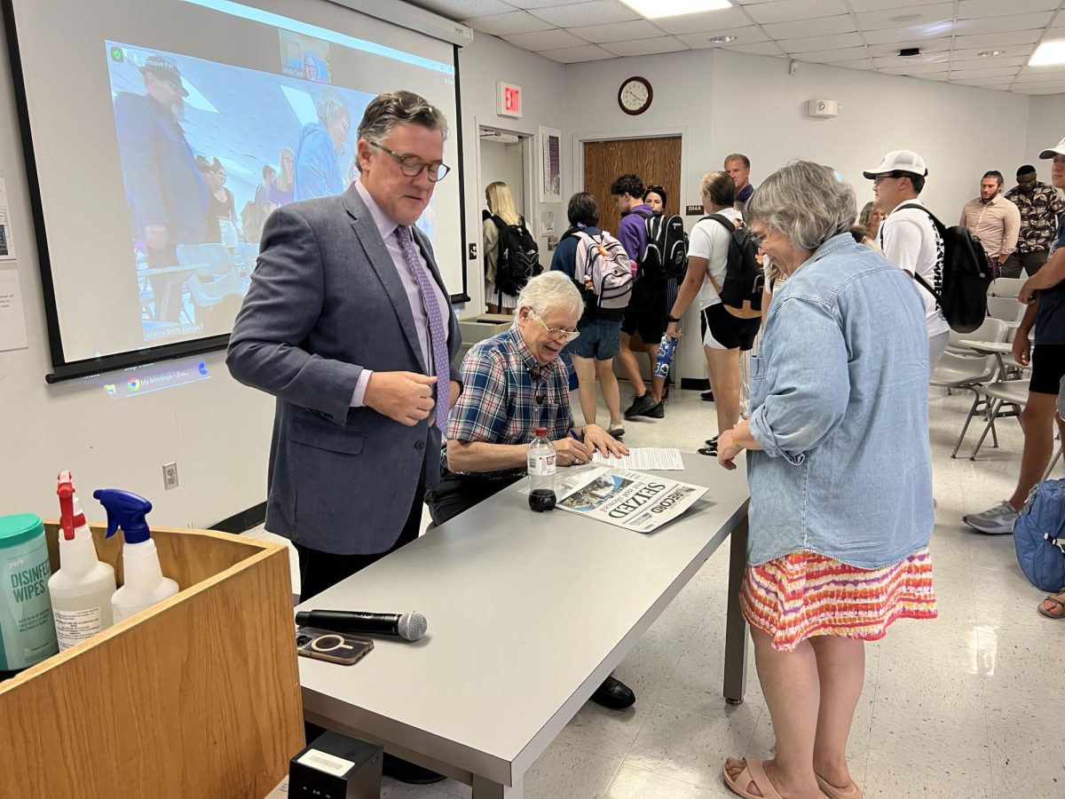 Marion County Record editor and publisher Eric Meyer signs a newspaper after he spoke to professor Andrew Smith's class on Sept. 1, 2023. Meyer has been in contact with Kansas legislators about possible legislation in the Kansas House of Representatives. (Archive photo)