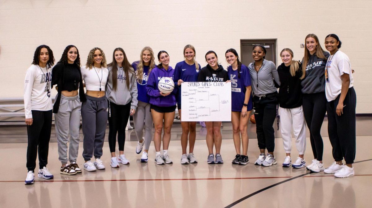 The winners of the women's bracket Sports Girls Club basketball tournament the "Wolfpack" stands with members of the women's basketball team after receiving their signed ball. The club is raising money for its members to attend a national conference in Boston. The tournament was held on Jan. 28 at the recreation center.