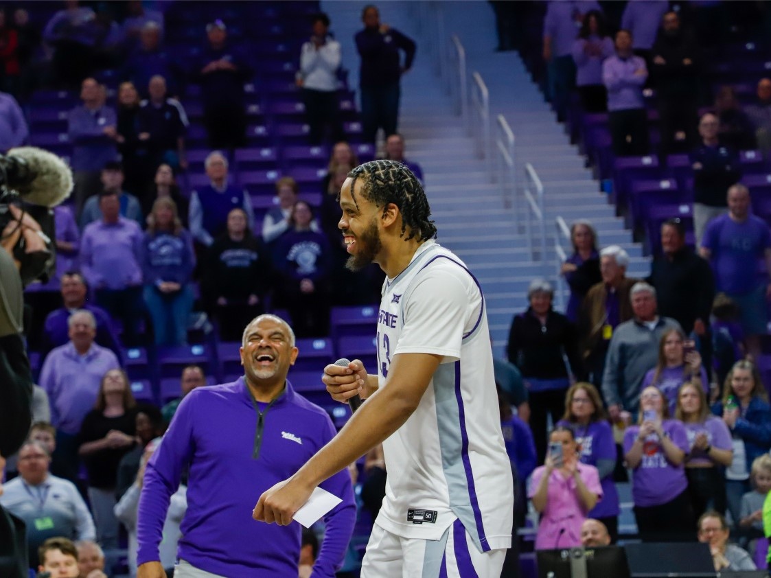 Center Will McNair Jr. cracks a joke into the mic, cracking up head coach Jerome Tang during the team's senior day celebration.