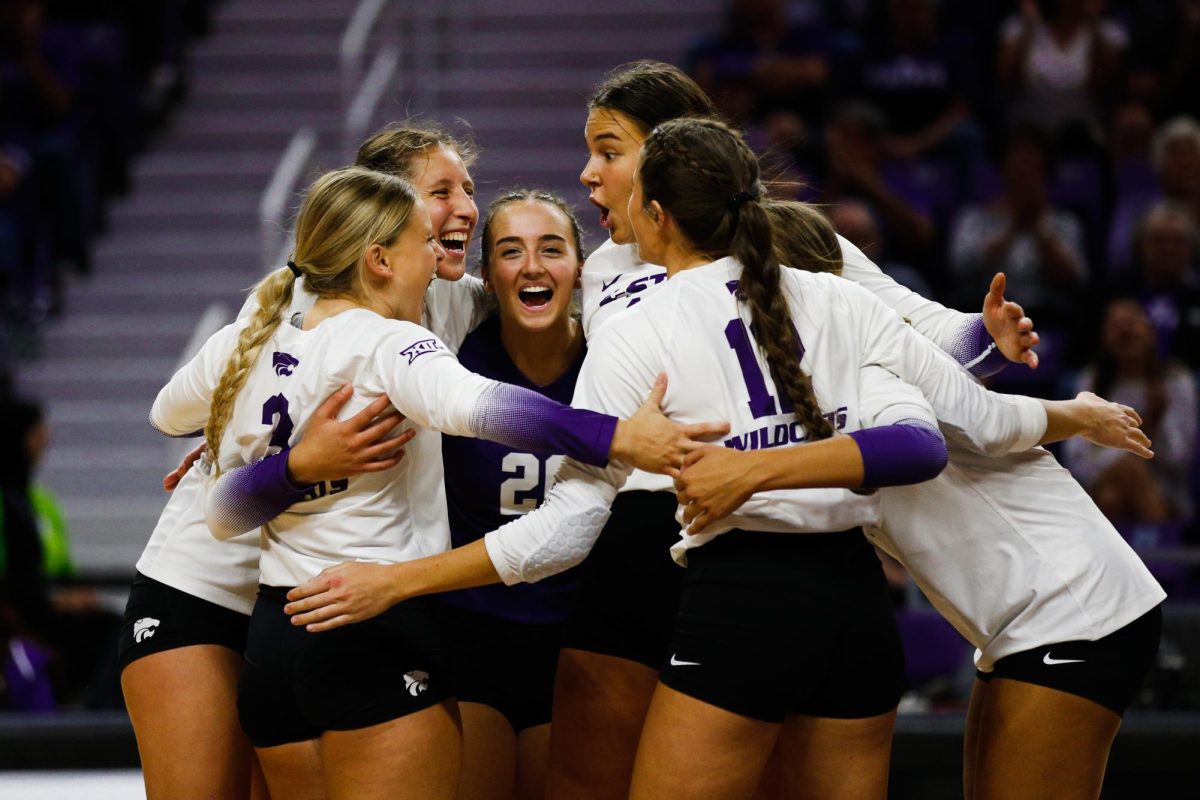 After a point, the volleyball team huddles in the middle of the court to celebrate the set during a fall 2022 game. 