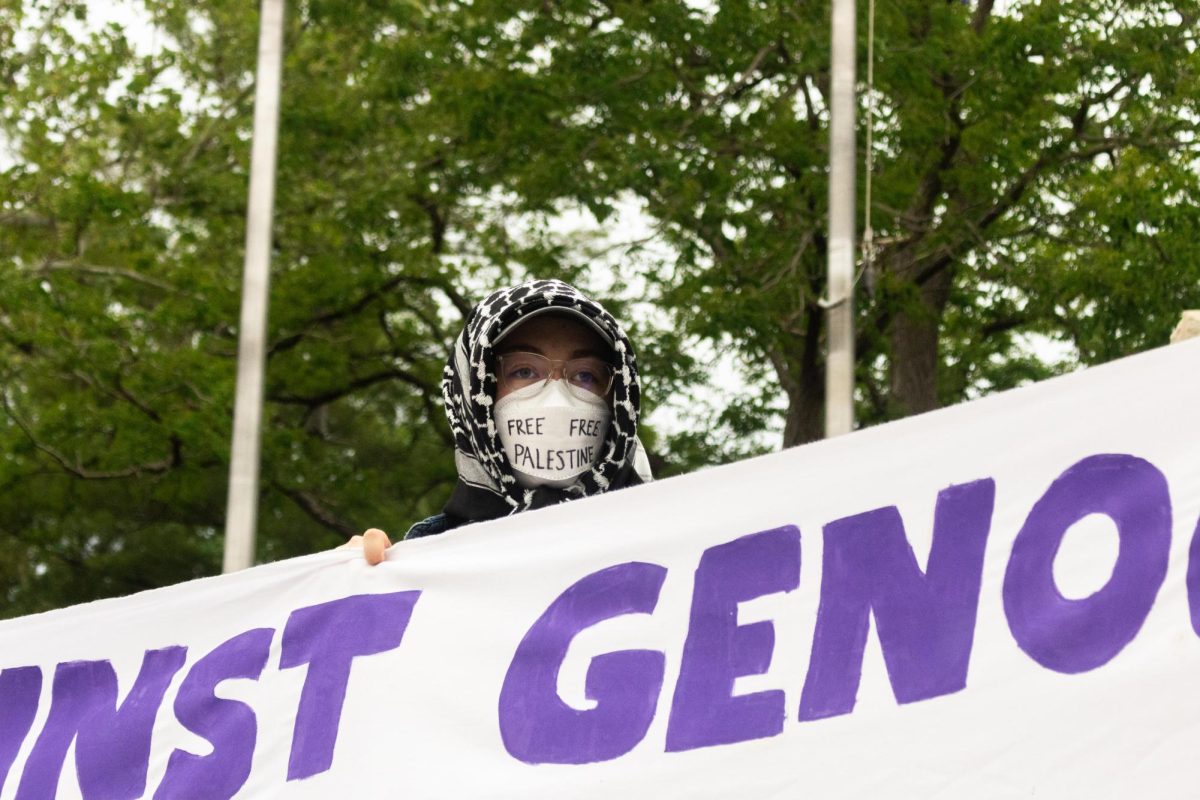 A Pro-Palestine protester wears a mask with "Free Palestine" displayed. The K-State Young Democratic Socialists of America club held a protest demanding K-State to divest from Israel. 