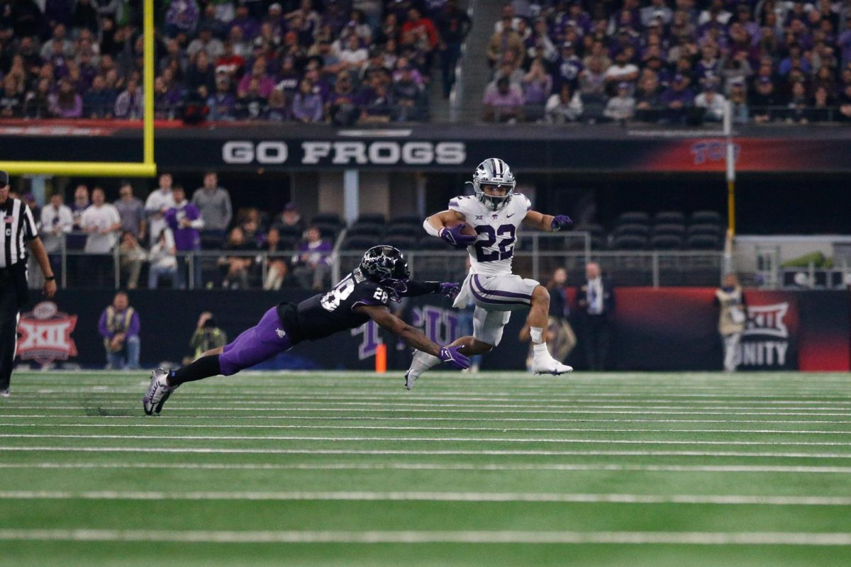 Evading tackles, junior running back Deuce Vaughn leaps out of reach of TCU defenders. K-State beat TCU 31-28 in overtime to win the Big 12 Championship at AT&T Stadium on Dec. 3, 2022. 