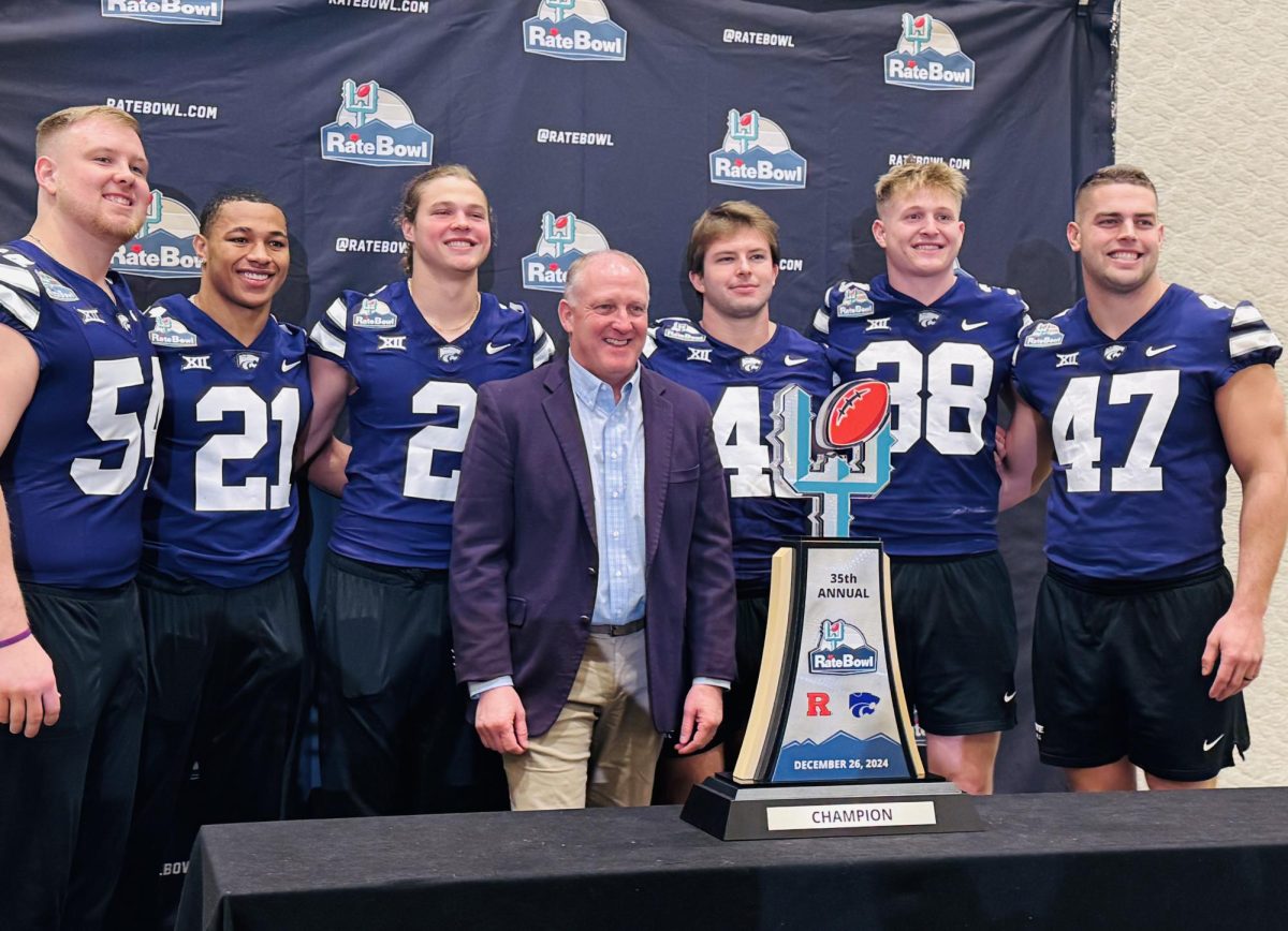 K-State captains and head coach Chris Klieman stand behind the 2024 Rate Bowl trophy. Austin Moore (41) and Brendan Mott (38) will play their final games as Wildcats after six years in Klieman's program.